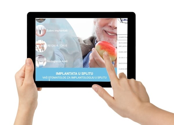 Der Finger zeigt auf dem Tablet auf unsere Implantat-Website
